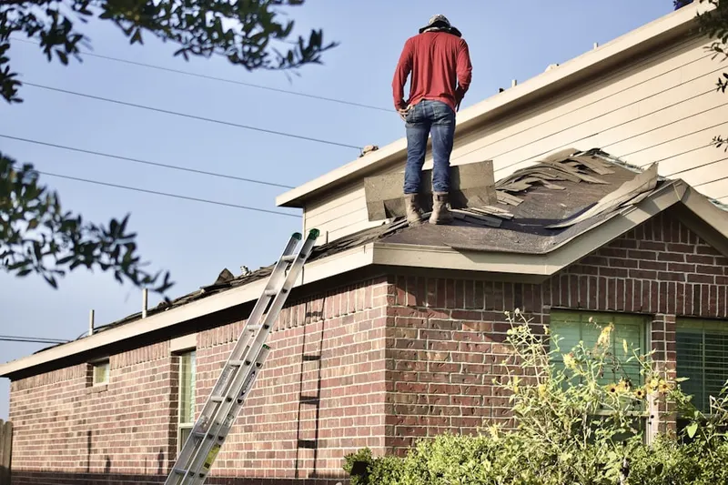 Professional roofer working on a residential roof in East Prentiss